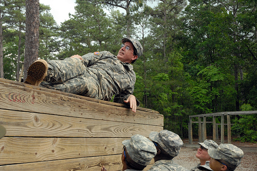 bootcamp2-500px Pvt. Stepehn Cobert rests atop one of the walls on the five-wall obstacle rather than aiding his fellow Soldiers who helped him reach the top.
